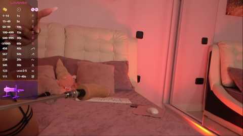 Video of a cozy, dimly lit living room with beige furniture and a white cushion. A woman, partially visible, is sitting on a chair, holding a microphone, surrounded by scattered objects.