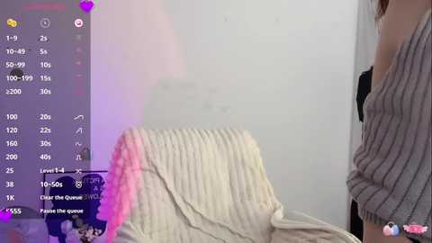 A video of a woman in a beige, ribbed sweater, partially draped on a chair, with a digital overlay showing a \"Level 15\" achievement and a \"Power Up\" button.