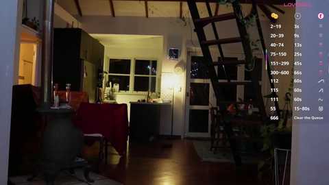 Video of a cozy, dimly-lit living room with wooden floors, a red armchair, a potted plant, and a wooden staircase leading upstairs.