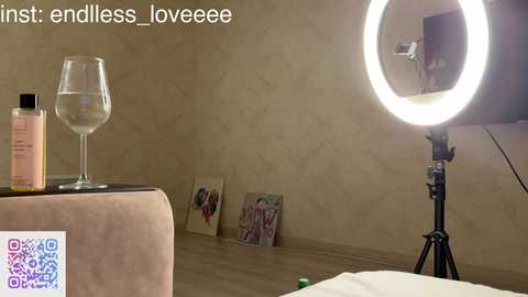 Video of a beige wall with a ring light and a glass of water on a table, featuring a \"first\" and \"endless\" Instagram caption.