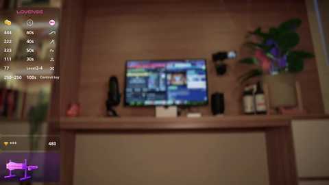 Video of a dimly lit living room with a flat-screen TV displaying an image, surrounded by various electronic devices, books, and plants on a wooden shelf.