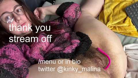 A video of a young woman with glasses and a pink and black sweater, lying on her back, revealing her pubic hair and genitals. Text reads \"thank you stream off\" and \"@kinny_malina twitter\".