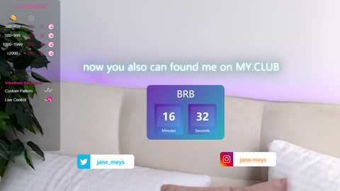 Video of a modern living room featuring a beige couch, a green plant, and a digital screen displaying \"BRB\" with two empty slots for avatars. The room is bright with soft, pastel-colored lighting.