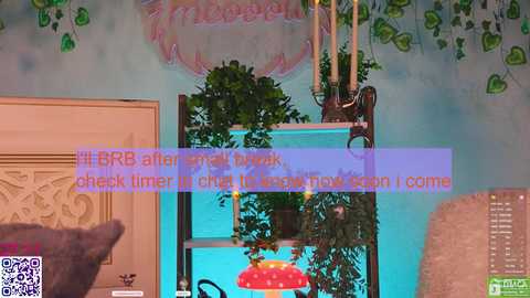 Video of a colorful, whimsical indoor scene featuring a teal wall with green foliage, a decorative wooden shelf with a red lamp, and a QR code overlay.