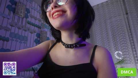 Media: Video of a young woman with short black hair, glasses, and a black choker with \"DICK\" engraved, smiling in a dimly lit room with a \"DMCA\" watermark and a \"Venus Creampie\" logo.