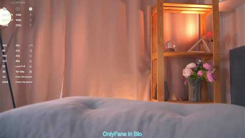 Video of a cozy bedroom with a wooden bookshelf, pink flowers, and soft lighting.