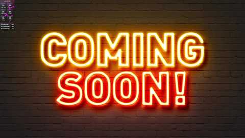 Media: Video of a neon sign against a dark brick wall, with \"COMING SOON!\" in bold, yellow letters. The sign's glow casts a warm, inviting light, highlighting the brick's texture.