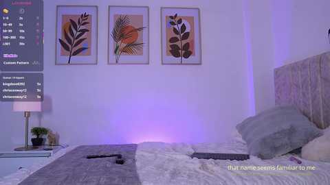 Video of a modern bedroom with a large bed covered in grey and white bedding, featuring abstract leaf paintings on the wall, a bedside lamp, and a \"Thai name says it all\" text overlay.