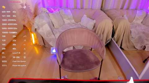 A video of a cozy living room with beige furniture, a light-colored chair, and ambient purple lighting, captured from a security camera view.