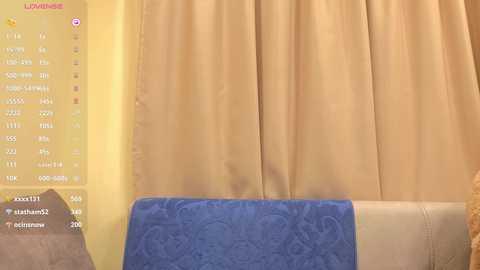 A video shows a beige curtain draped over a cream-colored sofa with a blue cushion. On the left, a yellow background displays a \"Lumie\" app interface with options for light therapy.