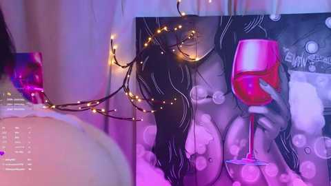 Video of a cozy, dimly-lit room with a black-and-white nude painting, a glass of wine, and a string of fairy lights, creating a romantic, sensual ambiance.