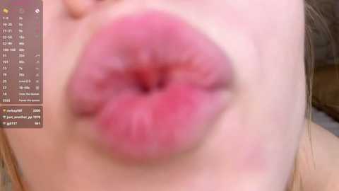 A close-up video of a light-skinned person's lips, with pink lipstick, in a blurred, slightly out-of-focus state. The background includes a partially visible digital calendar interface.