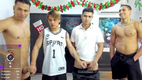 Video of four shirtless, muscular men with varying skin tones and tattoos, wearing basketball jerseys, standing in a festive room adorned with holiday decorations.