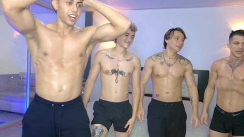 Video of four shirtless, muscular men wearing black boxer briefs in a modern, dimly-lit living room, showcasing tattoos and smiling.