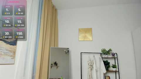 Video of a modern bedroom with beige curtains, a white wall, a small shelf with potted plants, a hanging mirror, and a temperature display overlay.