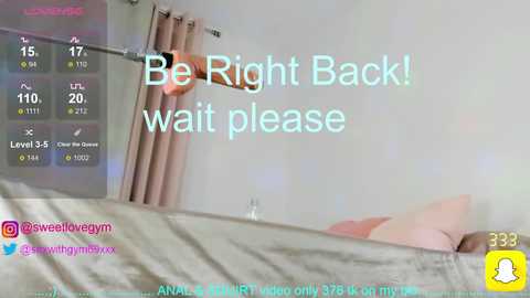 Video of a woman in a bed, urging viewers to \"Be Right Back! Wait please.\" Text overlays a live stream overlay.