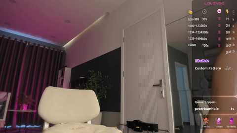 Video of a modern, minimalist bedroom with a white chair, dark curtains, and a closed white door. Live stream overlay shows chat messages, user stats, and a \"Twitch\" logo.
