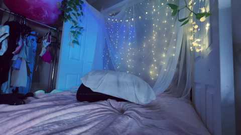 Video of a cozy bedroom with a white canopy bed, fairy lights, and a pink inflatable heart.