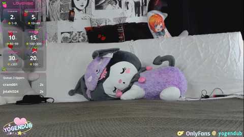 A video of a plush toy lying on a white bedspread in a dimly lit room, with a live stream overlay showing viewers and chat messages.