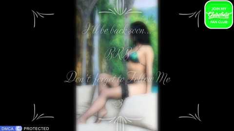 Video of a nude woman with dark hair, seated on a white cushioned bench, surrounded by lush greenery. Text overlay: \"Don't forget to tell me.\