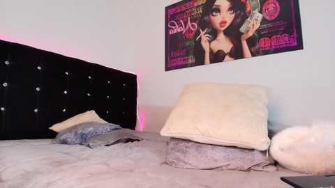 Video of a modern bedroom with a black tufted headboard, a plush cream pillow, a gray blanket, and a colorful pop art poster featuring a stylized woman holding a phone.