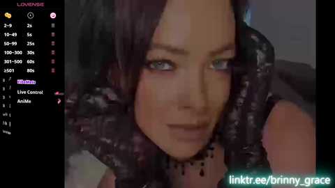 A video of a young woman with dark hair, light skin, and striking blue eyes, partially covered by a black snake. The image is overlaid with streaming platform text and the watermark \"link,ree,bri,my,grace.\