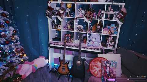 Video of a cozy bedroom with a white bookshelf filled with toys, a guitar, and a Christmas tree adorned with lights and ornaments.