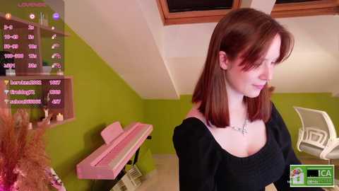 Media: A video of a fair-skinned woman with shoulder-length auburn hair in a black top, standing in a modern room with lime-green walls, a pink grand piano, and a white chair.