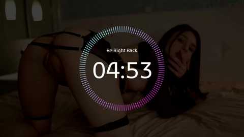Media: A dimly lit video shows a woman in black lingerie bent over, her face partially obscured by a digital overlay of a clock reading \"04:53.\