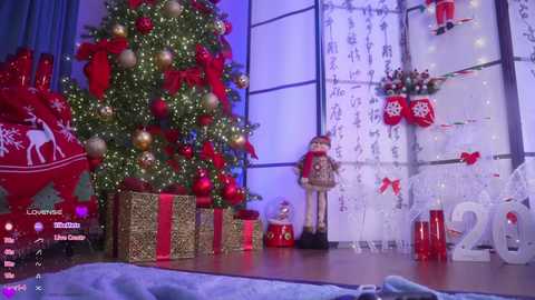 Video of a festive room with a decorated Christmas tree, wrapped gifts, a Santa figurine, and a large \"2020\" number display in a cozy, holiday-themed setting.