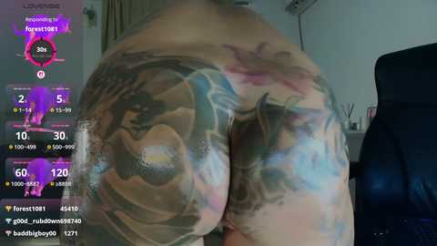 Video of a woman with a large, colorful tattoo of a mermaid on her backside, partially covered in water, in a dimly lit room.