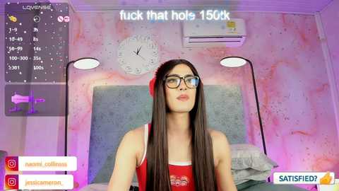 Video of a young woman with long dark hair, wearing red lingerie, red lipstick, and glasses, in a pink-themed bedroom. Text above reads \"fuck that hole 1500k.\