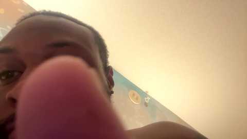 Video of a close-up, low-angle view of a person's nose and upper lip, with a soft, warm indoor light illuminating the scene.