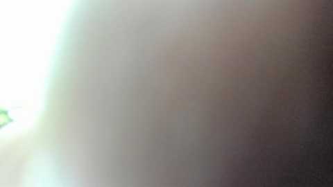 A blurry, close-up video of a person's arm, with skin tones transitioning from light to dark, hinting at a possible tattoo or bruise. The background is out of focus.