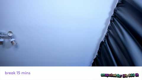 Video of a bathroom wall with a broken 15-minute timer, a silver faucet, and a black curtain partially covering a window.