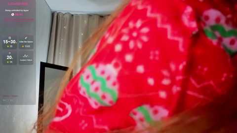 Video of a person wearing a red, patterned Christmas pajama shirt, with a blurred background showing a bed and a TV. The image includes a digital clock and a text overlay with statistics.