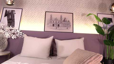 Video of a bedroom with a lavender wall, two large white pillows, a beige blanket, and a framed black-and-white photo of a castle.