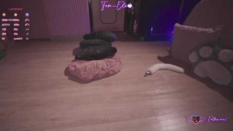 Media: A video of a virtual room with a cat in a pink blanket on a wooden floor, surrounded by plush toys and a \"Tent-Evil\" watermark.