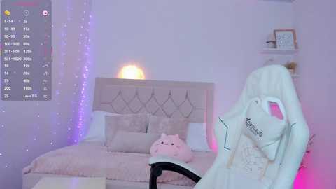 A video of a white rabbit costume standing in a pastel-themed bedroom with a bed, pink pillows, and string lights.