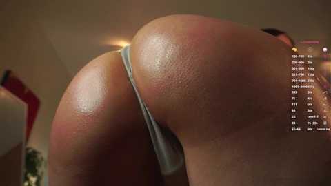 Media: A video of a close-up view of a woman's toned, tanned buttocks in light blue thong underwear, set in a dimly lit room with blurred background elements.
