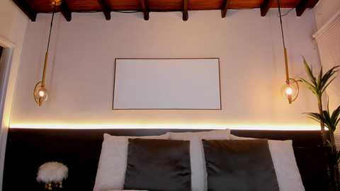 Video of a modern bedroom with a white wall, black headboard, two pendant lights, and a minimalist aesthetic.