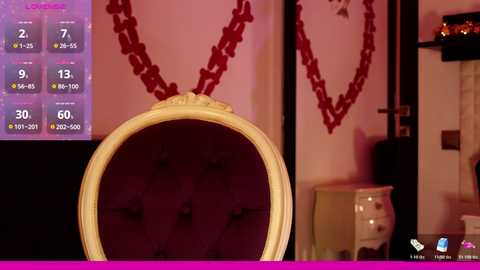 A video of a plush, velvet-tufted chair with a gold frame in a dimly lit, elegant room. A digital game interface with stats and a chain necklace is visible in the background.