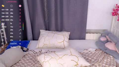 Video of a cozy bedroom with a white bed, grey curtains, and a grey and white geometric-patterned duvet. A smartphone with a \"Lounging\" app displays on the left, showing a list of activities and a \"Meditation\" icon.
