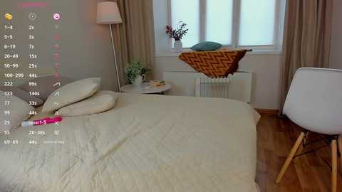 Media: A video of a cozy, minimalist bedroom with a white bed, beige curtains, wooden floor, and a modern white chair.