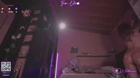 A dimly-lit, low-quality video of a woman with wet hair, standing in a bedroom with pink walls, a teddy bear, and a bunk bed, taken from a first-person perspective.