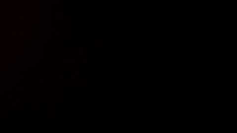 A video featuring a stark black background with minimal light, creating a sense of depth and mystery. The image is devoid of any discernible objects or details, emphasizing the void.