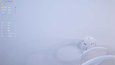 Media: A video of a minimalist white room with a sleek, modern ceiling fan and a small, white, round speaker. The background is plain and the lighting is soft, creating a serene, clean aesthetic.