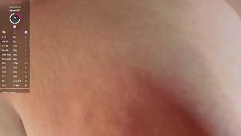 Video of a close-up view of a person's buttocks, showing a reddish-purple bruise on the left cheek, with a calendar in the top left corner. The skin tone is light, and the background is out of focus.