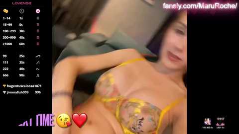 Media: A blurred photo of a woman in a yellow bra with a floral pattern, taken from an angle, with a username \"marufRocher\" and \"fame\" tags.