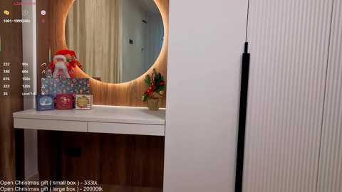 Video of a modern bathroom with a circular mirror, wooden vanity, festive decorations, and a white cabinet door.
